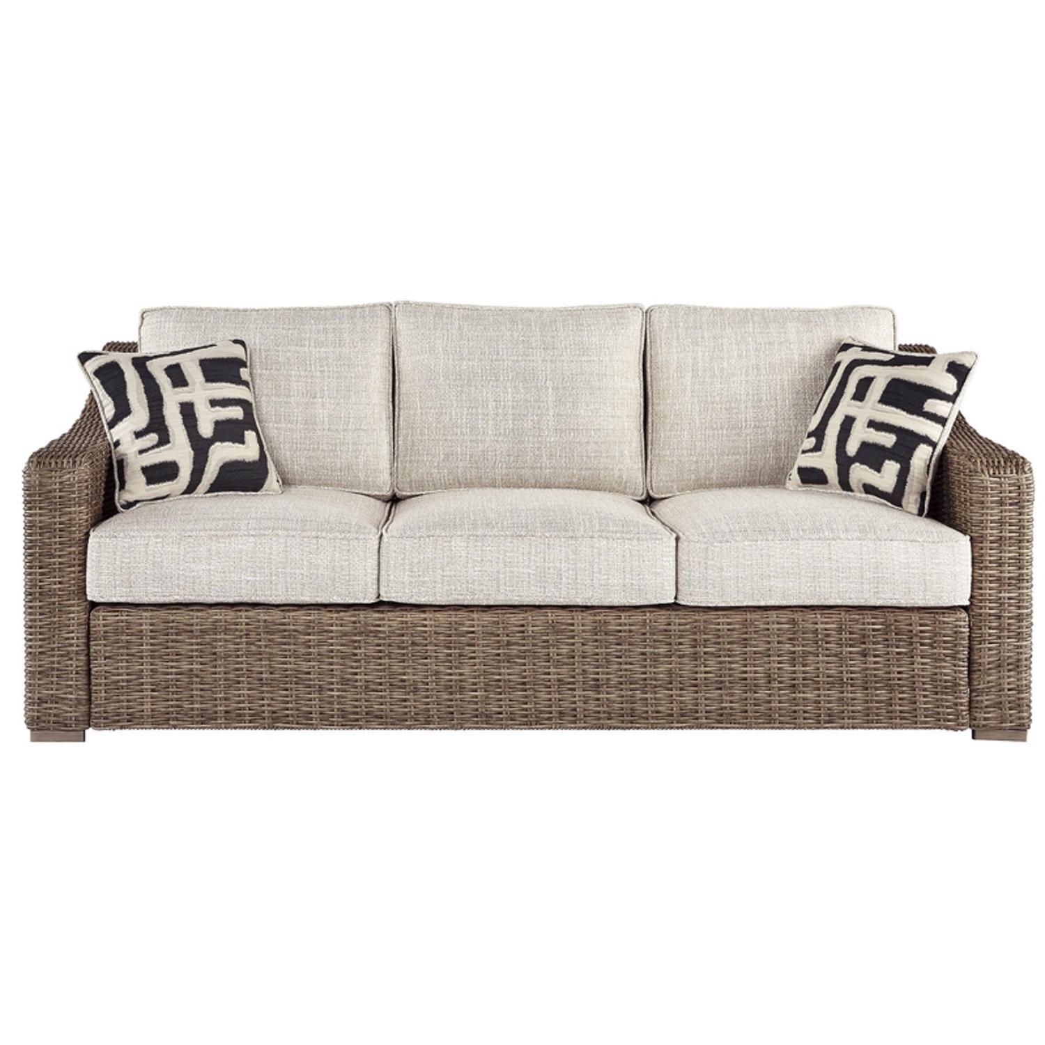 Outdoor wicker sofa with beige cushions and pillows